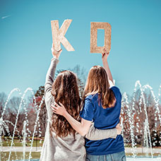 Collegians holding KD glitter letters. Link to Life Stage Gift Planner Ages 45-65 Situations.