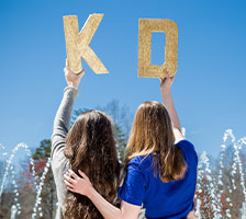 Collegians holding KD glitter letters. Link to Life Stage Gift Planner Ages 45-65 Gifts.